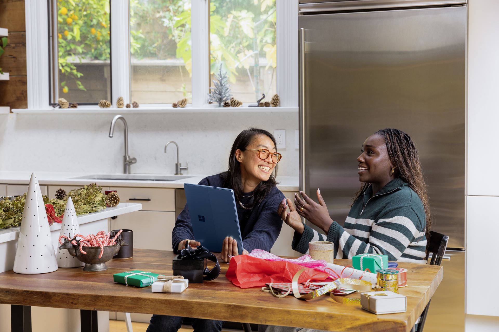 Two women sitting together in front of a computer screen.