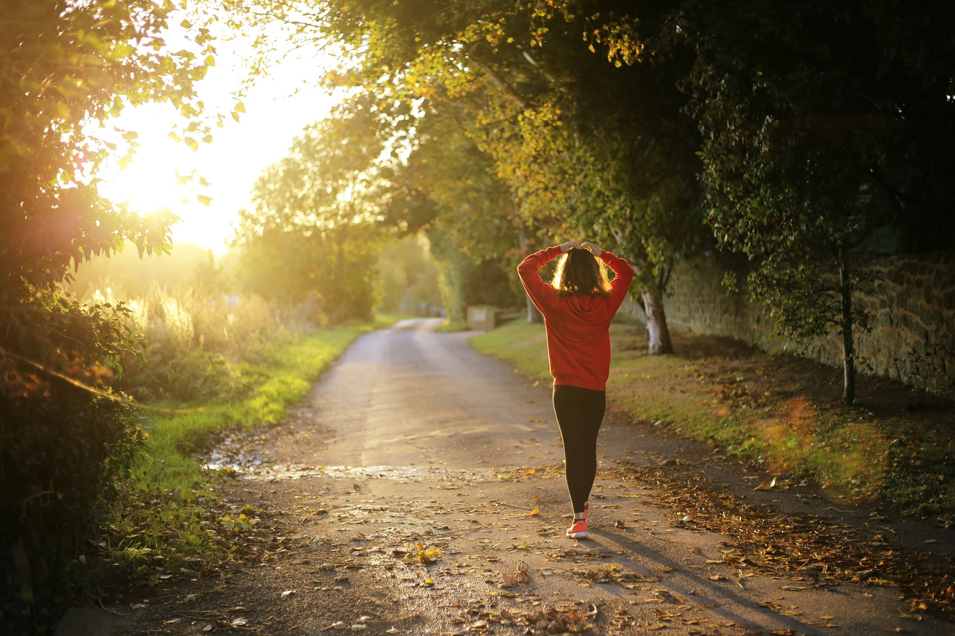 A woman standing in a park at sunset