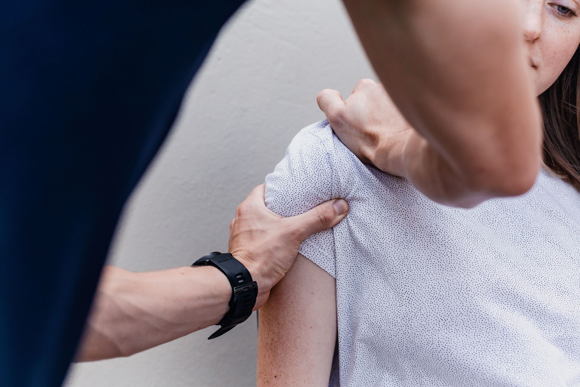 A physiotherapist manipulating a woman's shoulder
