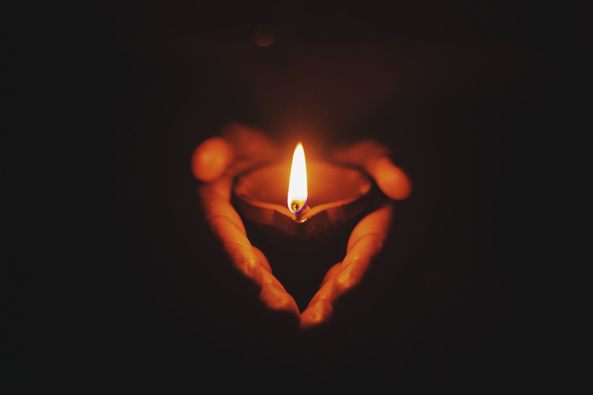 A candle held in cupped hands