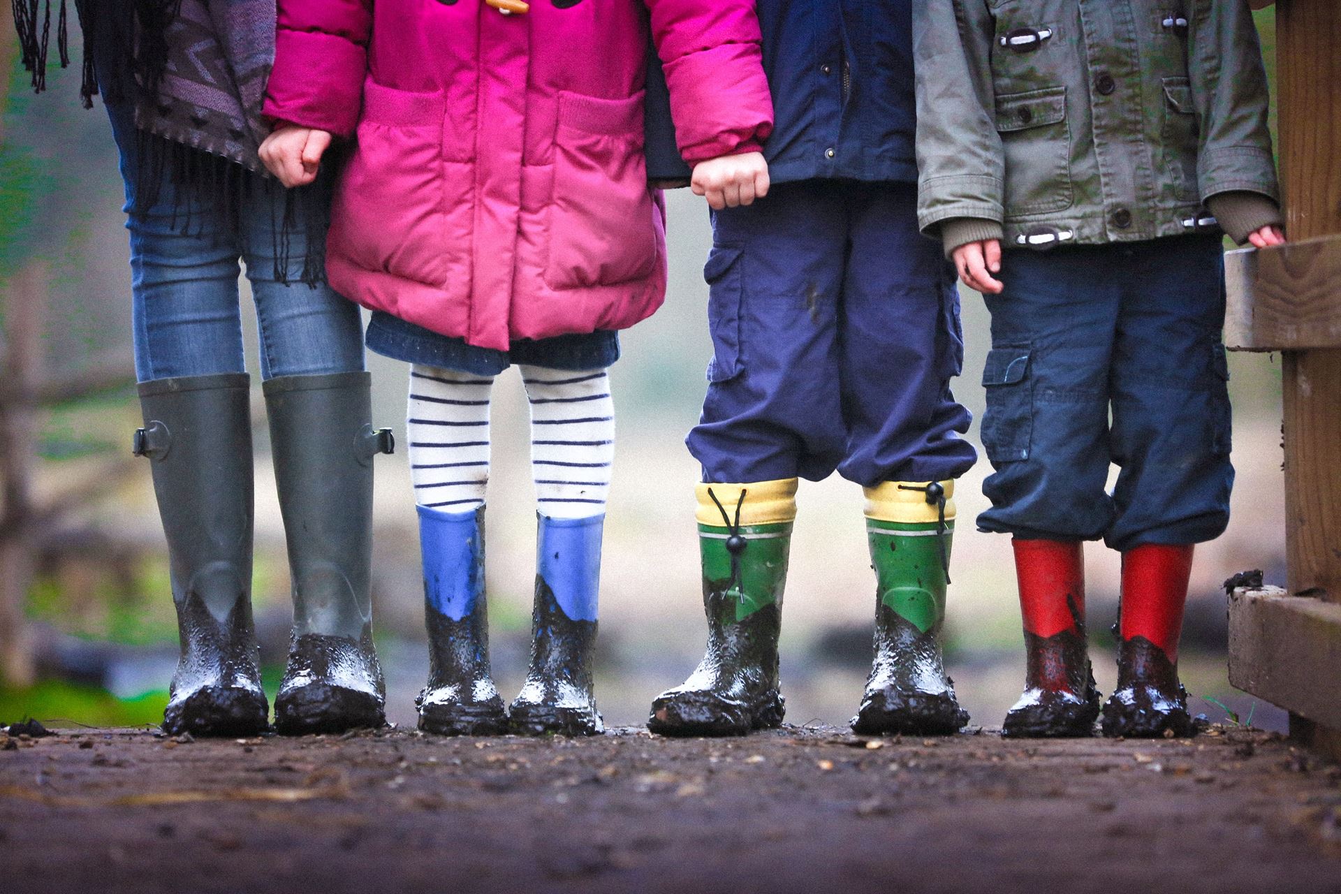A family seen from waist down, all wearing wellington boots