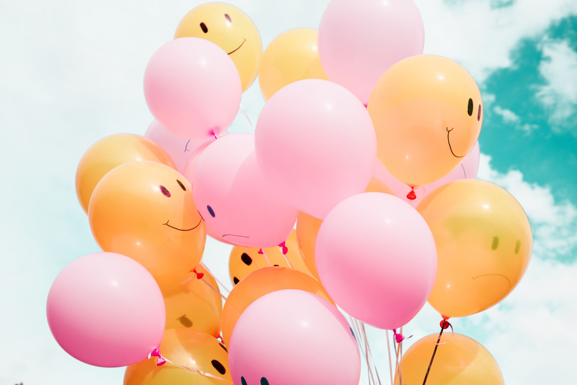 A cluster of balloons with smiley faces